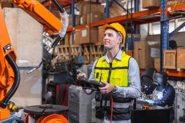 Modern robot teknolojisi kullanan akıllı, modern mühendis erkek. Fabrikada otomasyon üretim sürecinde robotik kaynak kolu kurulumu