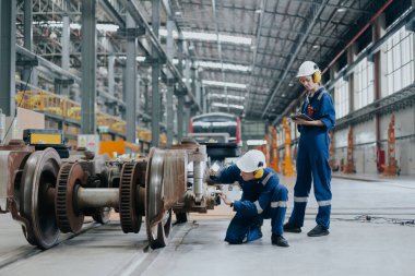 Profesyonel elektrik treni mühendisi tren servisi müfettişi tren istasyonu atölyesindeki rayları kontrol ediyor.