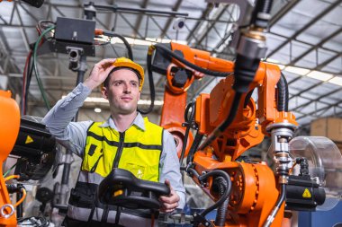 Modern robot teknolojisi kullanan akıllı, modern mühendis erkek. Fabrikada otomasyon üretim sürecinde robotik kaynak kolu kurulumu