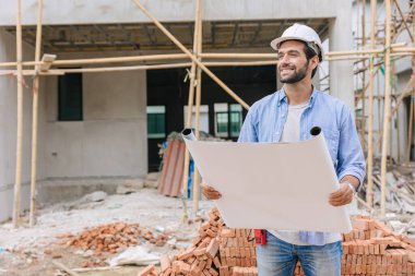 İnşaat mühendisi inşaat alanında çalışıyor. Mimari ev projesi ustabaşı baş tasarımcı kat planından memnun.