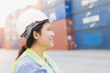 Asyalı kadın, tersanedeki konteynırları yükleyen mutlu liman işçisi kontrolü. Denizci ve taşıyıcı personel müdürü. kargo yükleme operatörü lojistik yönetimi.