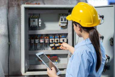 Elektrik Mühendisi kadın, sanayi fabrikasında kontrol servisi bakım, elektrik ana şalteri ve güç sisteminde çalışıyor.