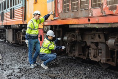 Mühendislik ekibi bakım, tren istasyonundaki kırık dizel tren parkı, güvenlik giysisiyle çalışıyor..