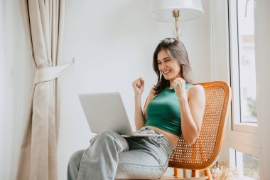 Evde dizüstü bilgisayarı olan genç bir kadın neşeli bir başarı kazandı.