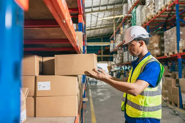 warehouse african black male worker. inventory clerk staff stock employee work in cargo storage shelf check remaining products order for shipping.