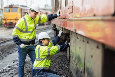 Mühendislik ekibi bakım, tren istasyonundaki kırık dizel tren parkı, güvenlik giysisiyle çalışıyor..