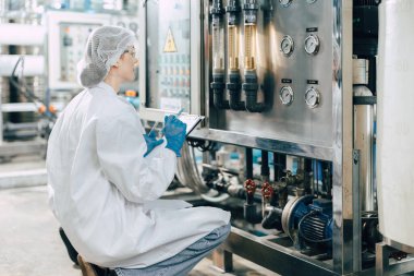 İçme suyu fabrikasında çalışan temiz hijyen içeceği fabrikası kalite kontrol akış ölçer su arıtma makinesi işlemini izleyen işçiler..