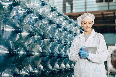 İçki fabrikasında çalışan kadın işçiler, şişe depolama çeklerini hijyen üniformasıyla birlikte sayıyorlar..