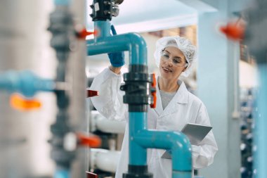 Su fabrikası arıtma işlemi. Hijyen fabrikası işçisi kadın monitör valf ve su borusu üretim kontrol.