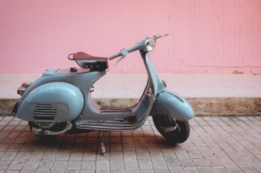 Eski model motosiklet antika klasik motosiklet scooter stili park yeri şehir sokaklarının pembe duvarında