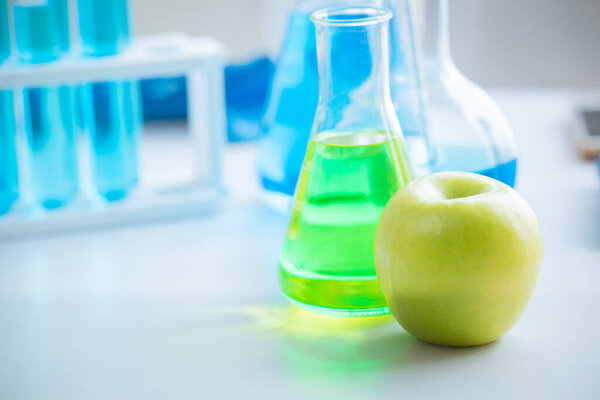 Green Apple in food science lab for high antioxidant bio flavonoid vitamin C nutrition healthcare extraction from fruit.