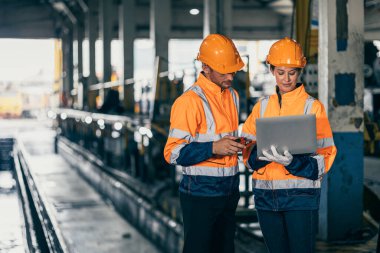 Engineer safety officer team man and women working together with laptop checking inspect in heavy industry building factory. clipart