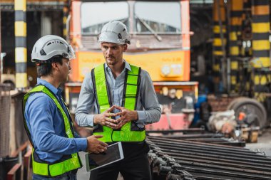Lokomotif tren nakil işinde birlikte çalışan profesyonel mühendis ekibi lokomotif bakım atölyesindeki yedek parçaları kontrol ediyor..