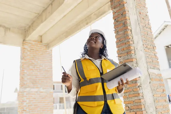 Engineer women black african professional worker working inspection quality check of construction site house building project.