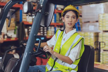 Depo işçisi, Asyalı genç çalışan kadınlar ağır iş yükü taşıyan yük konteynırları forklift ile dolduruyorlar.