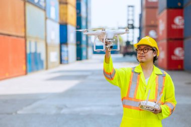 Personel çalışanı liman konteynırındaki drone hava görüntüleme sistemini kullanıyor. UAV Devriyesi, lojistik kargodaki keşif ve güvenlik alanı için koruma teknolojisi.