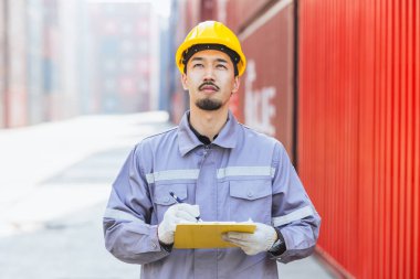Japon erkek akıllı işçi konteynır limanında çalışıyor. Japon nakliye sektörü lojistik gümrük personeli.