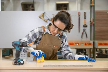 Mutlu kadınlar ahşap atölyesinde çalışan tasarımcıları severler. Birleştirici ahşap önlük işçi mobilya el yapımı fabrika.