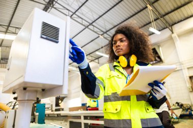 Afrikalı siyahi kadın işçiler ahşap kesici makine mobilya fabrikası ve güvenlik kıyafeti ile çalışıyorlar.