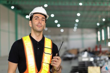 Portre depo müdürü, güvenlik görevlisi erkek telsizle fabrika kargosunu kontrol ediyor.