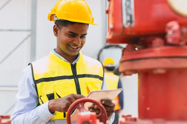 happy indian engineer safety staff worker work control operate valve gas pipe oil industry