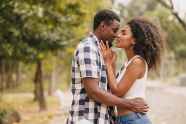 Sevgililer Günü 'nde çift olarak çıkacaktık. Parkta Afrikalı siyahi aşıklar yaz mevsiminin klasik tonlarında