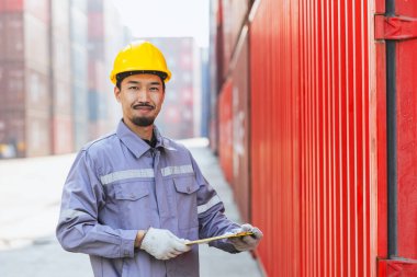 Japon erkek akıllı işçi konteynır limanında çalışıyor. Japon nakliye sektörü lojistik gümrük personeli.