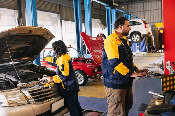 Garage auto mechanic worker working check engine oil level stick in car service center employee teamwork