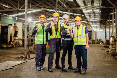 Ağır sanayide çalışan mühendis erkek ekip bir arada duruyor. Profesyonel insanlardan oluşan bir grup mutlu bir takım çalışması..