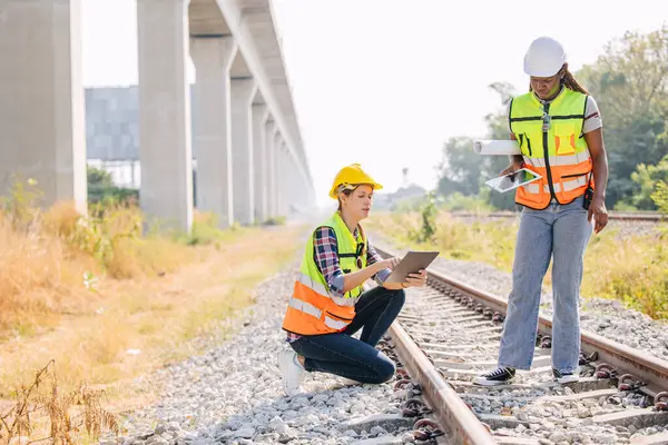 Engineer female railway tracks service team working on site survey check maintenance inspection train track for new construction and safety check
