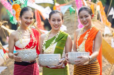 Songkran festivali. Geleneksel giyinmiş Kuzey Taylandlı insanların portresi Songkran 'ın yaz günü Tayland kültür festivalinde el yapımı gümüş kase kullanılıyor..