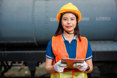 Portre treni lokomotif mühendisi kadın işçi. Genç Asyalı mutlu gülümseme tabletli çek servis bakım treninin keyfini çıkar..