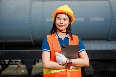 Portre treni lokomotif mühendisi kadın işçi. Genç Asyalı mutlu gülümseme tabletli çek servis bakım treninin keyfini çıkar..