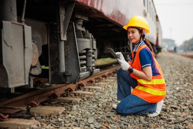 Tren lokomotifi mühendisi kadın işçi. Tablet bilgisayar yazılımı kullanan genç Asyalı kontrol servisi bakım treni.