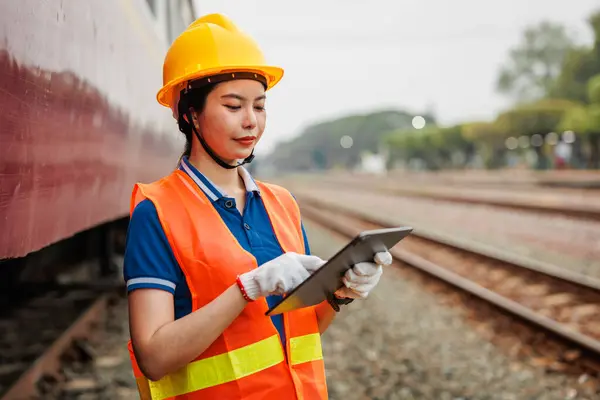 鉄道機関車エンジニアの女性労働者 ティーン アジア チェック サービス メンテナンス タブレット コンピュータ ソフトウェアを使用して ロイヤリティフリーのストック写真