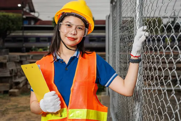 肖像画の若い女性労働者は安全のハードハードで幸せな笑顔を立っています 業界で働くスマートな従業員の女性 ロイヤリティフリーのストック画像