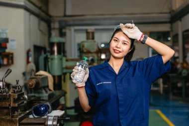 Susamış işçi mutlu mutlu gülümseme içme suyu dinlenme sıcak işyeri metal atölye ağır endüstri dinlenme.