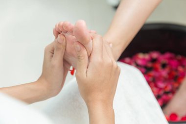 Ayak masajı yapan el, tek beneğe basıyor. Ağrı kesici ayaklar, güzellik salonundaki kozmetik bakım.