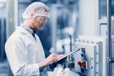 Bilim Laboratuarı 'nda çalışan bilim adamı tıbbi fabrika çalışanı. İlaç fabrikası teknisyeni Bakım Bakım Bakım Ürünleri Kalitesi Sterilize Odasında Not Alma Listesi.