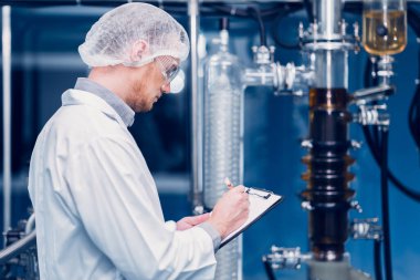 Bilim Laboratuarı 'nda çalışan bilim adamı tıbbi fabrika çalışanı. İlaç fabrikası teknisyeni Bakım Bakım Bakım Ürünleri Kalitesi Sterilize Odasında Not Alma Listesi.