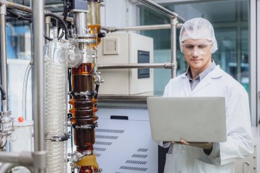 Bilim Laboratuvarında ekipmanla çalışan bir bilim adamı. Tıbbi fabrika personeli Kenevir CBD yağ çıkarma. Kenevir yağı ince film damıtma bitkileri süreci.