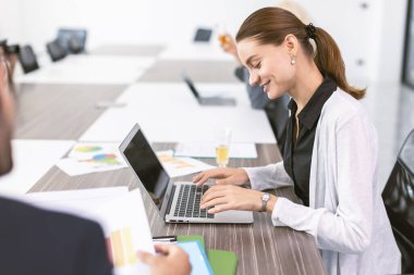 Ofis odasında patronla konuşan iş kadınları, pazarlama sekreteri müdürle masada çalışıyor.