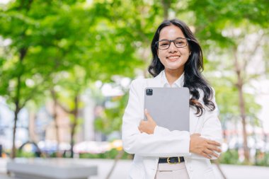 Hintli iş kadınlarının portresi mutlu bir gülümseme. Genç Asyalı başarılı iş kadınları yeşil şehir ofis parkında mutlu..