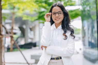Portre Zeki Hintli genç iş kadını kendine güvenen mutlu bir gülümseme. Yeşil şehirdeki iş kadınları..