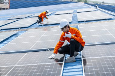 Profesyonel Mühendis Servis Güneş Paneli. İşçi Bakım Temizliği, Güneş Paneli Değiştirme. Sanayi çatısındaki güneş fotovoltaik panel sistemi. Enerji Temiz Güç ile Kaydediliyor.