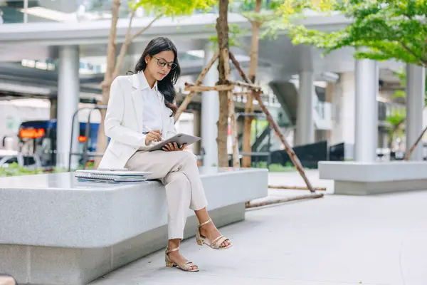 Stock image Business Young people. Asian Indian working women smart girl with tablet green park outdoor.