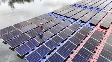 Mühendislik Servisi Yüzen Güneş Paneli hava görüntüsü 4K video kaydı. Profesyonel işçi, göl gölündeki güneş enerjisi çiftliğinin bakımını üstlendi..