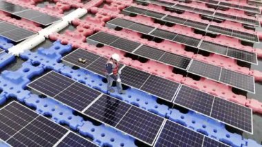 Mühendislik Servisi Yüzen Güneş Paneli hava görüntüsü 4K video kaydı. Profesyonel işçi, göl gölündeki güneş enerjisi çiftliğinin bakımını üstlendi..