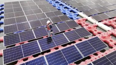 Mühendislik Servisi Yüzen Güneş Paneli hava görüntüsü 4K video kaydı. Profesyonel işçi, göl gölündeki güneş enerjisi çiftliğinin bakımını üstlendi..