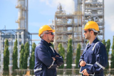 Petrol endüstrisi mühendisleri, dışarıda çalışan işçiler. Rafineri yağı ve gaz servisi ustabaşı tablet ve telsizle karmaşık gaz boru binasının bakımını üstleniyor..